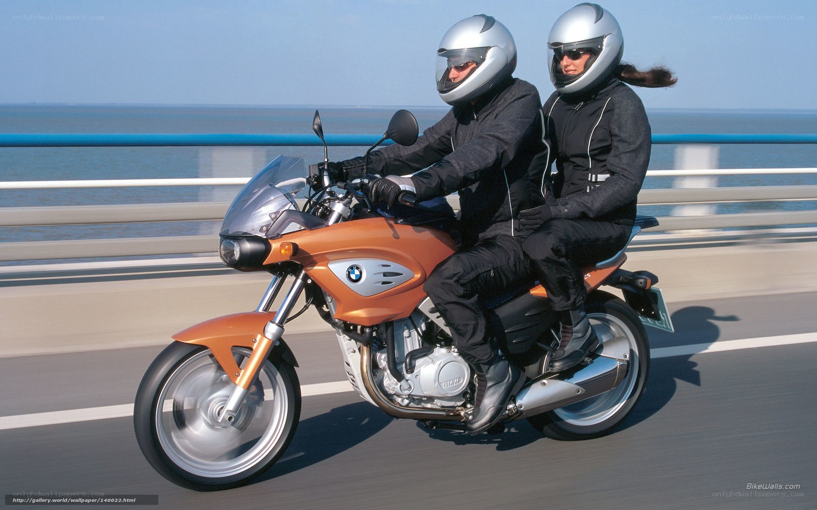 Couple riding orange motorcycle