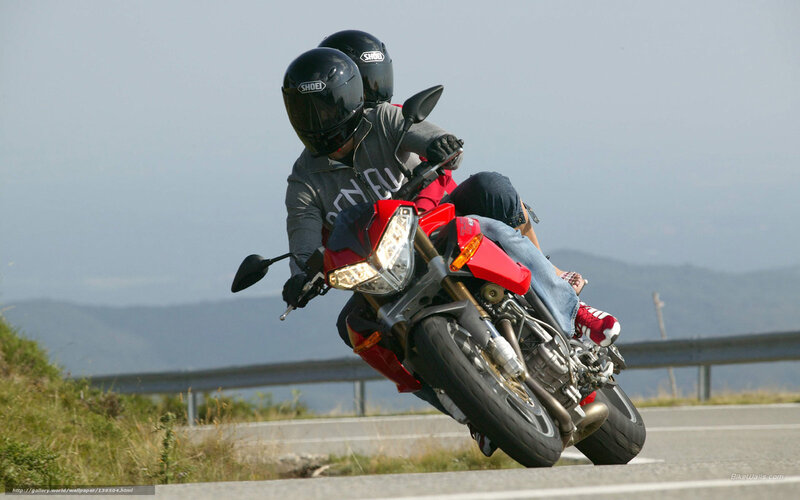 Couple riding red motorcycle