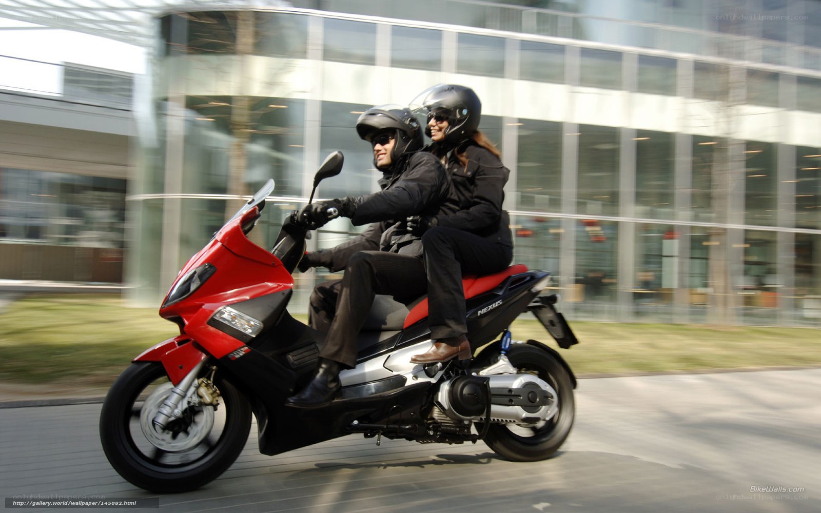 Couple riding red scooter