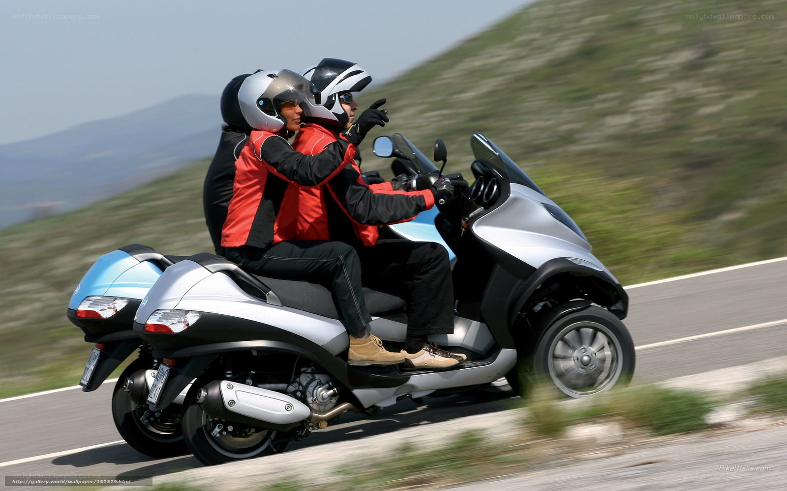 Couple riding scooter on road