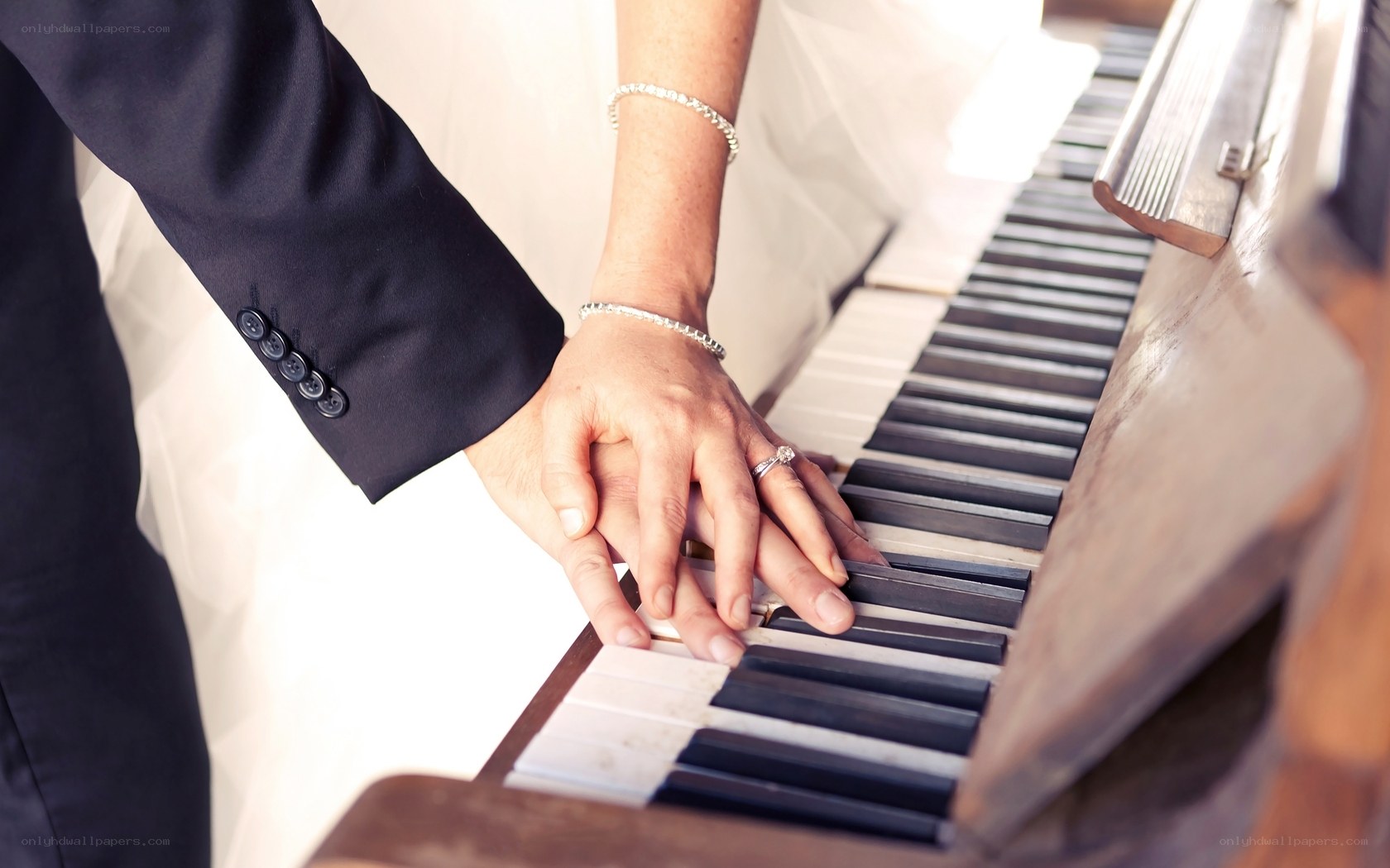 Couple's hands on piano keys