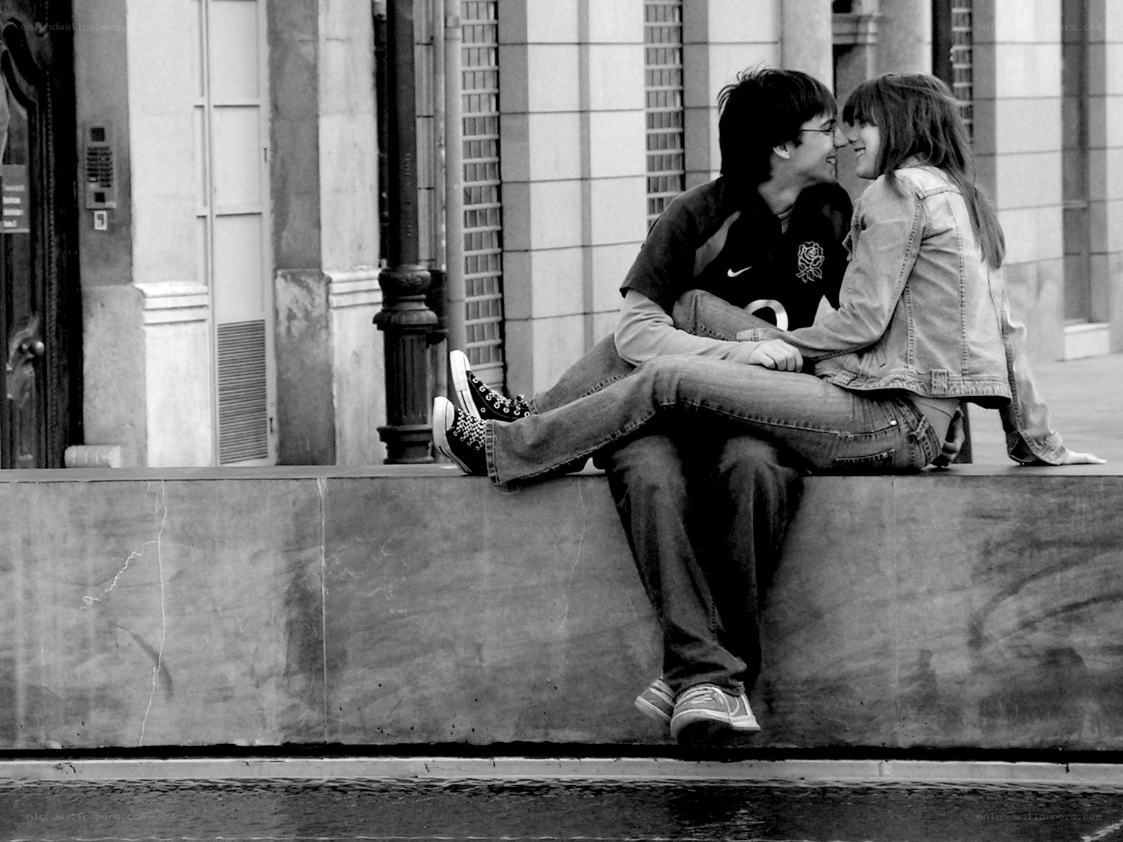Couple sharing a kiss on a ledge