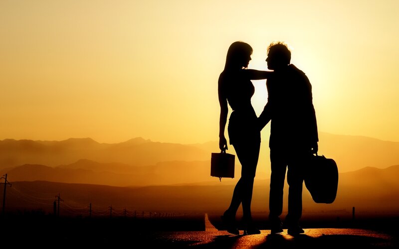 Couple Silhouetted at Sunset — Orange, Dramatic, Photograph, Mountains, Suitcases