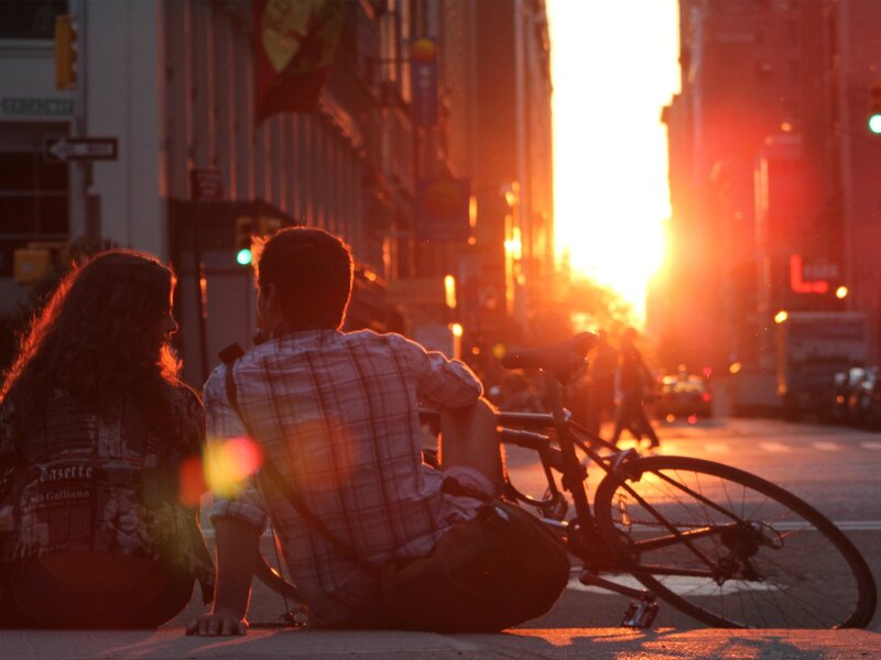 Couple sitting at sunset on city street