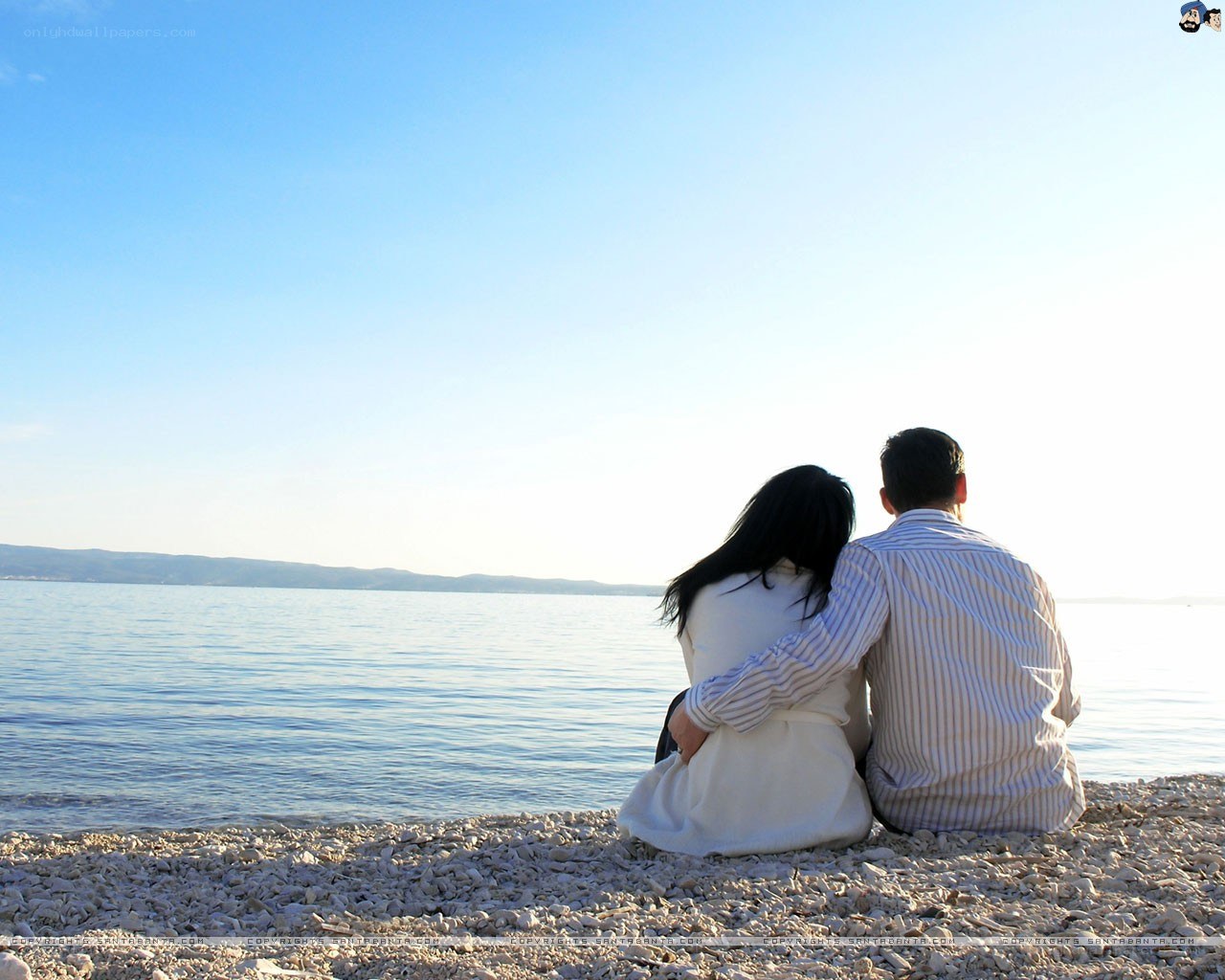 Couple sitting on a pebble beach