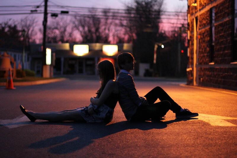 Couple sitting on the street at dusk
