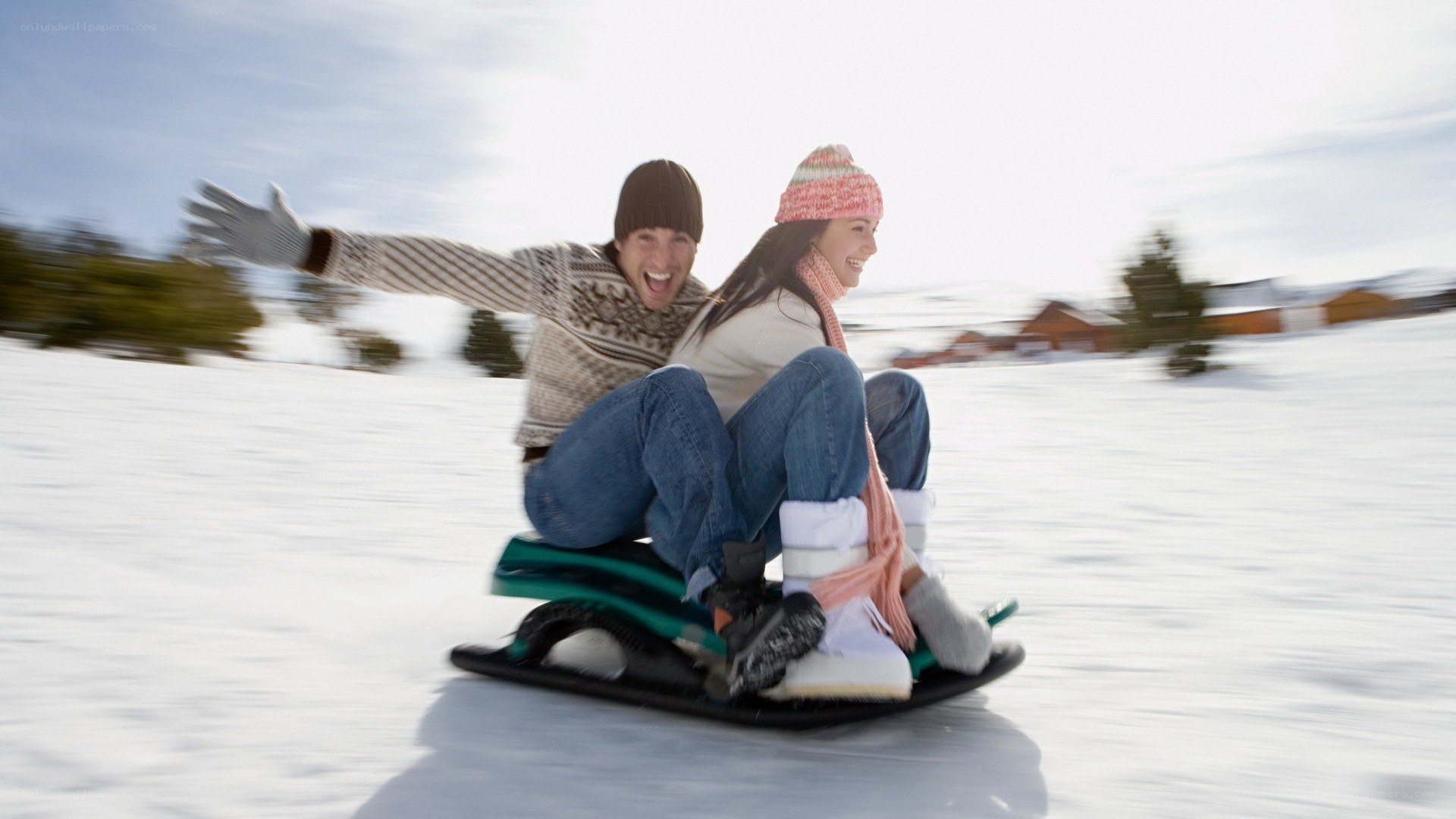 Couple sledding in snow