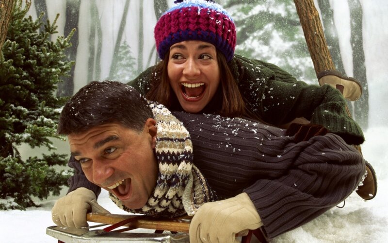 Couple sledding in snow