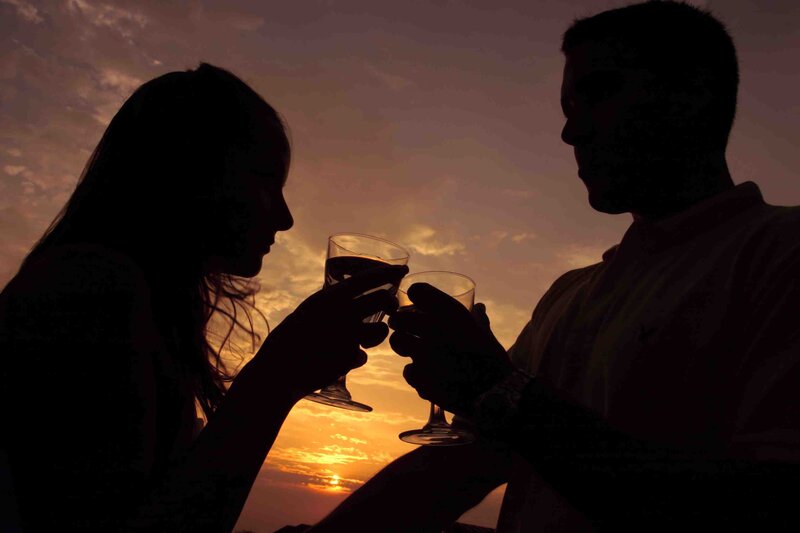 Couple toasting at sunset