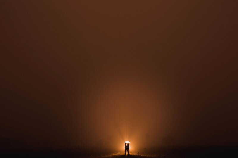 Couple under an umbrella in fog