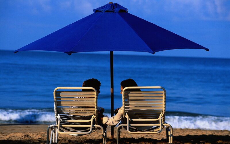 Couple under beach umbrella