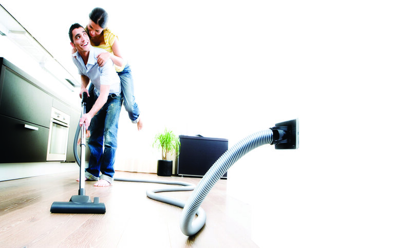 Couple using vacuum cleaner