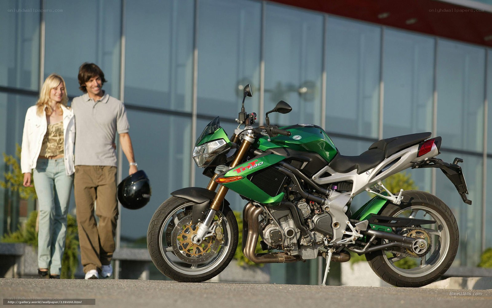 Couple walking near green motorcycle