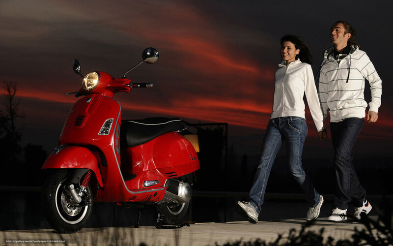 Couple walking near red scooter