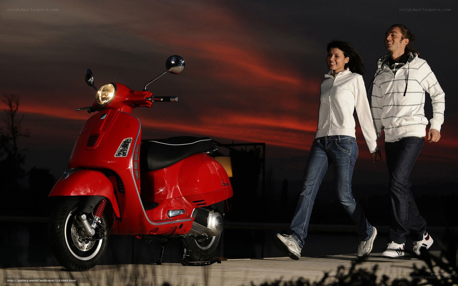 Couple walking near red scooter