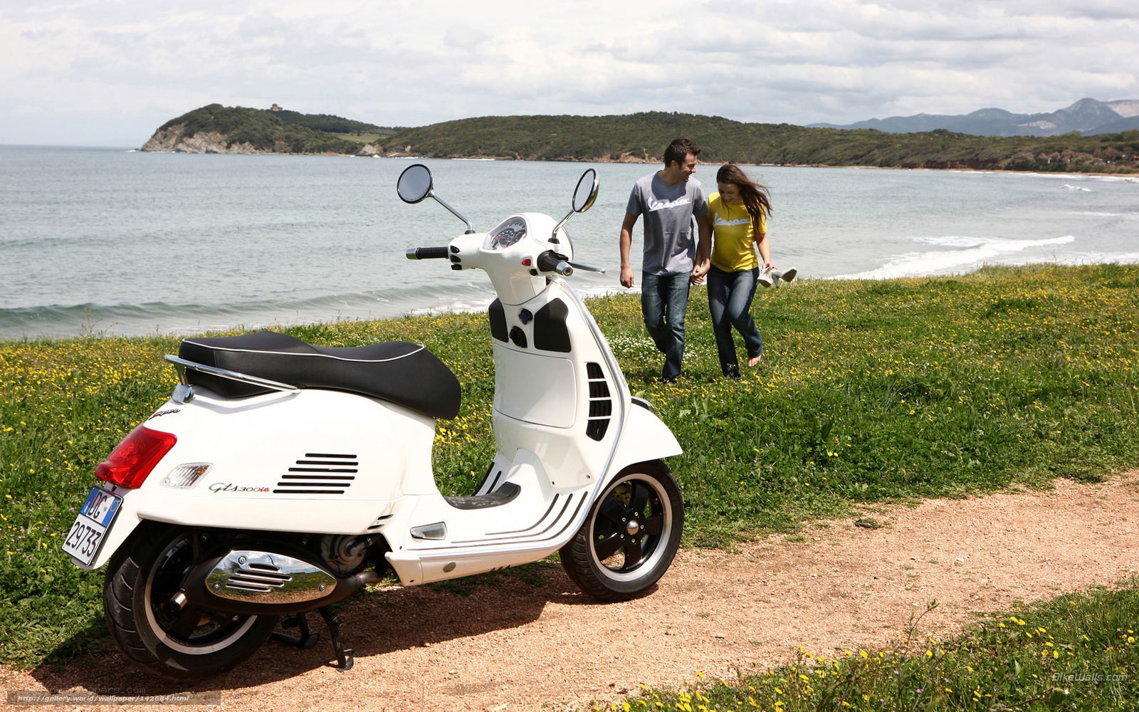 Couple walking near scooter by sea