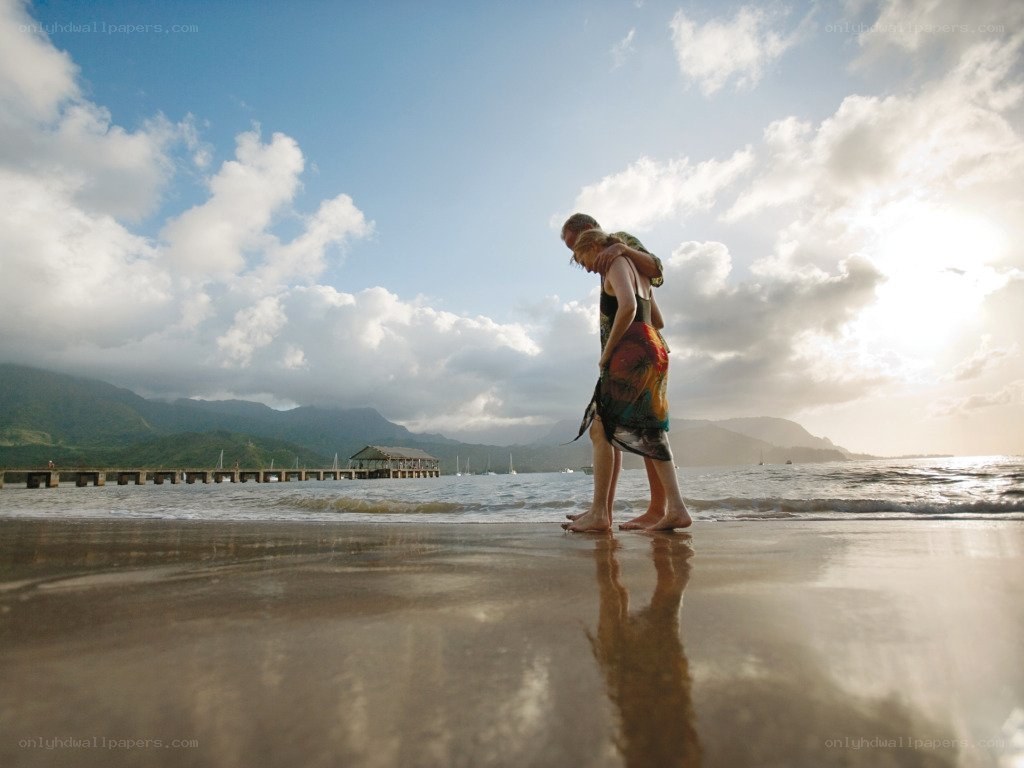 Couple walking on beach at sunset