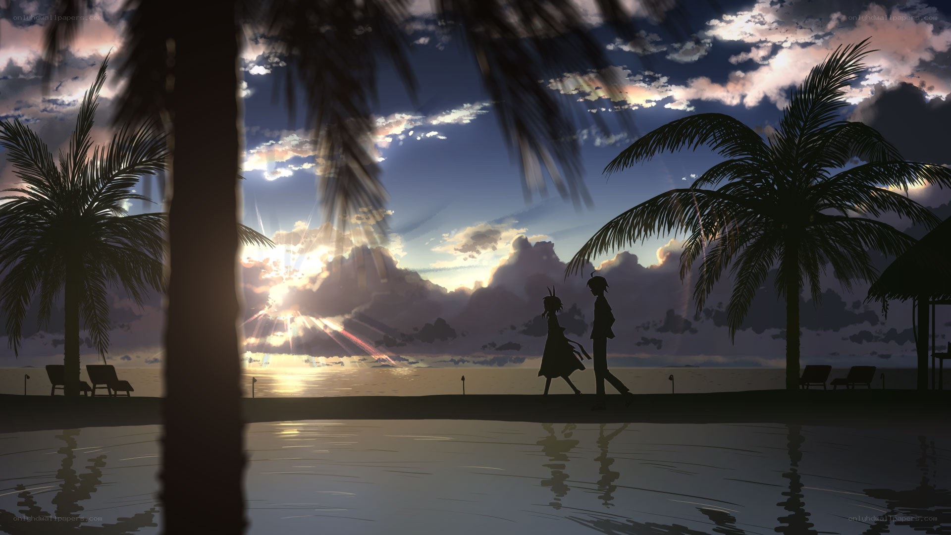 Couple walking on beach at sunset