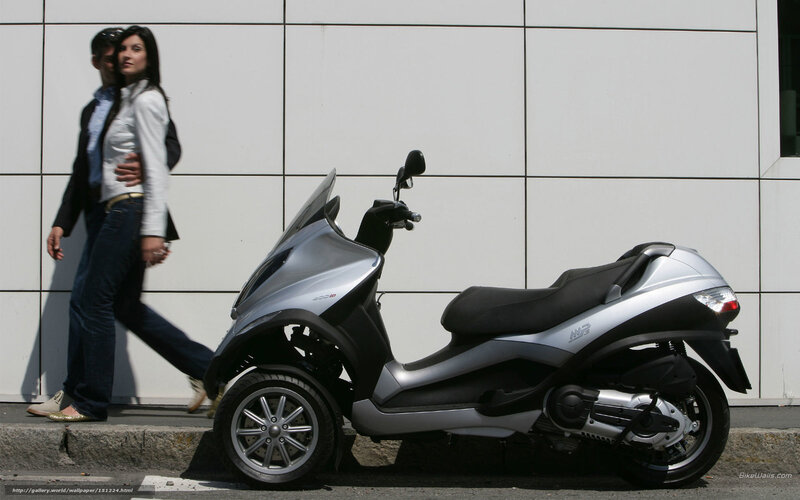 Couple walking past a scooter