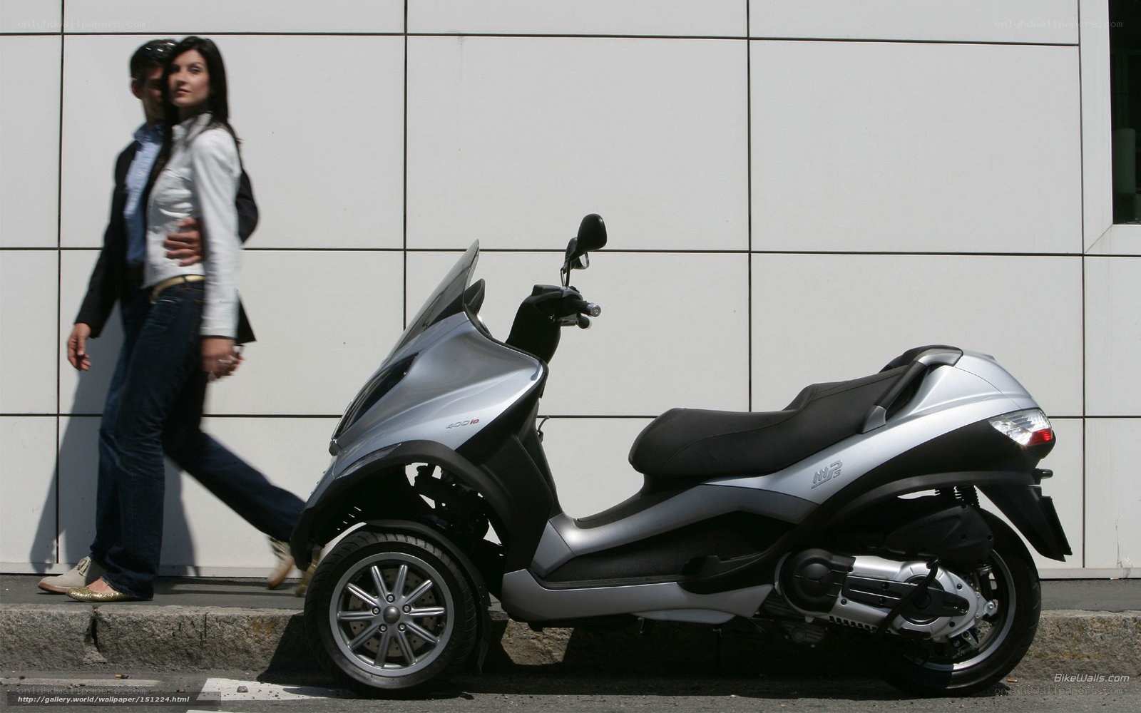 Couple walking past a scooter