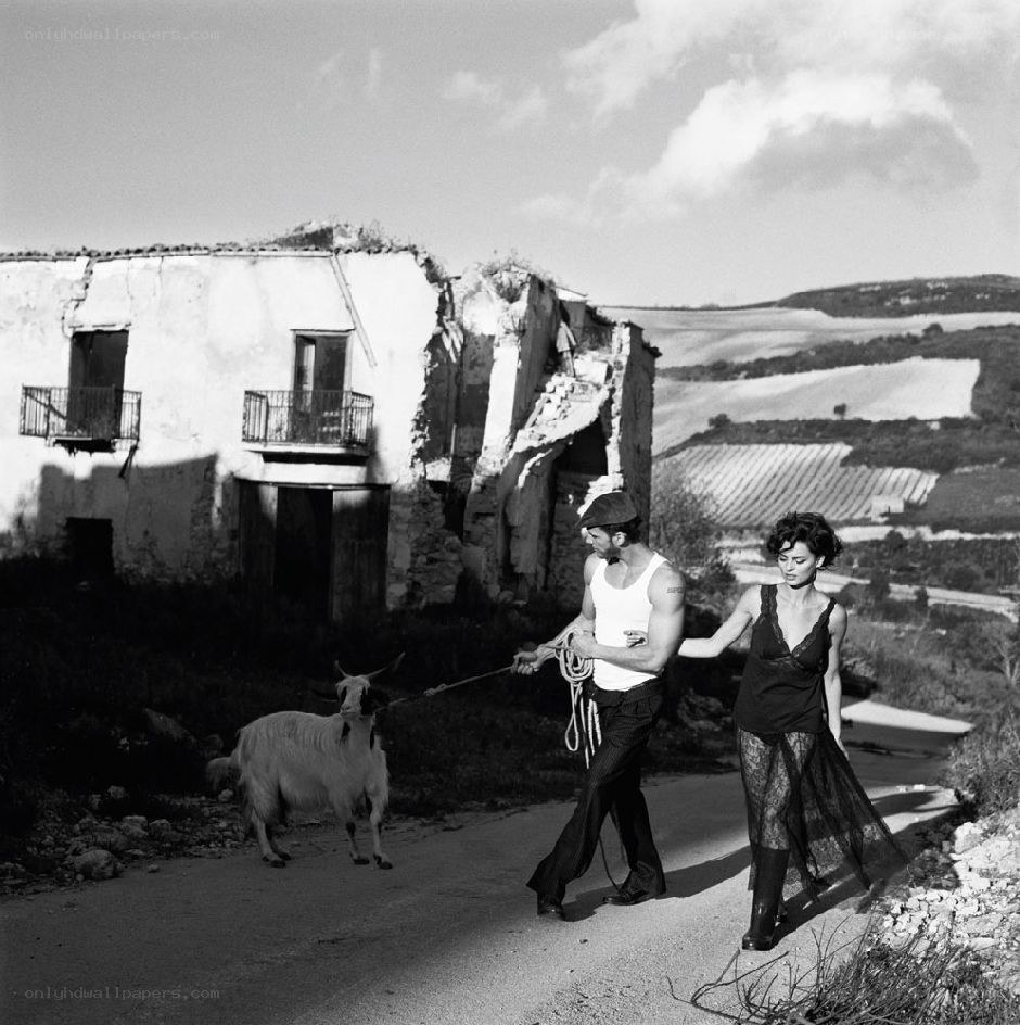 Couple walking with goat in ruins