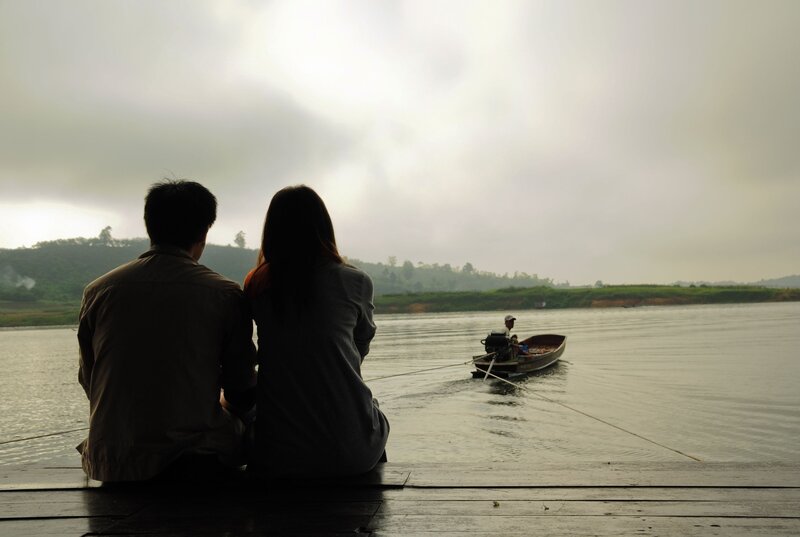 Couple watching boat on river