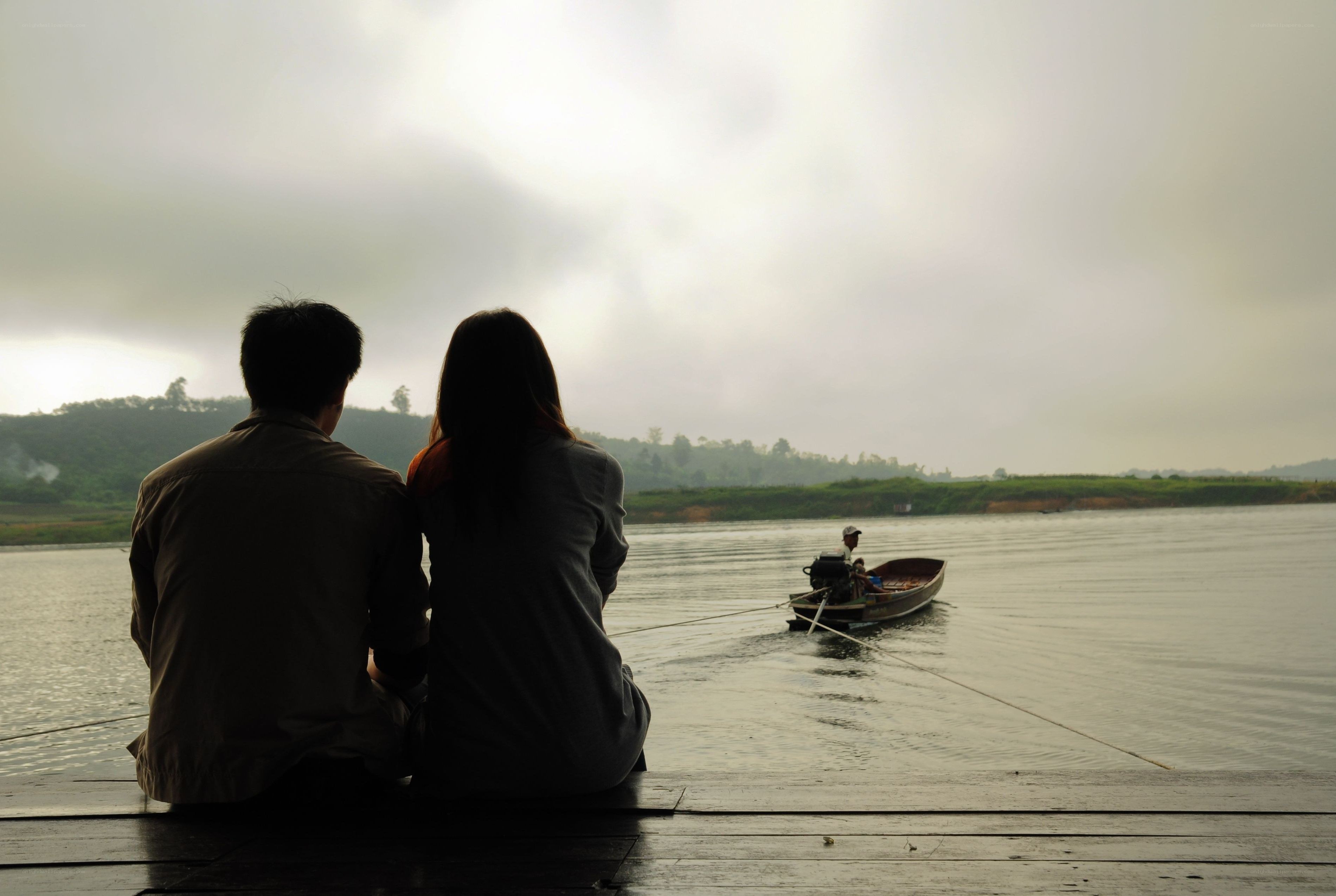 Couple watching boat on river
