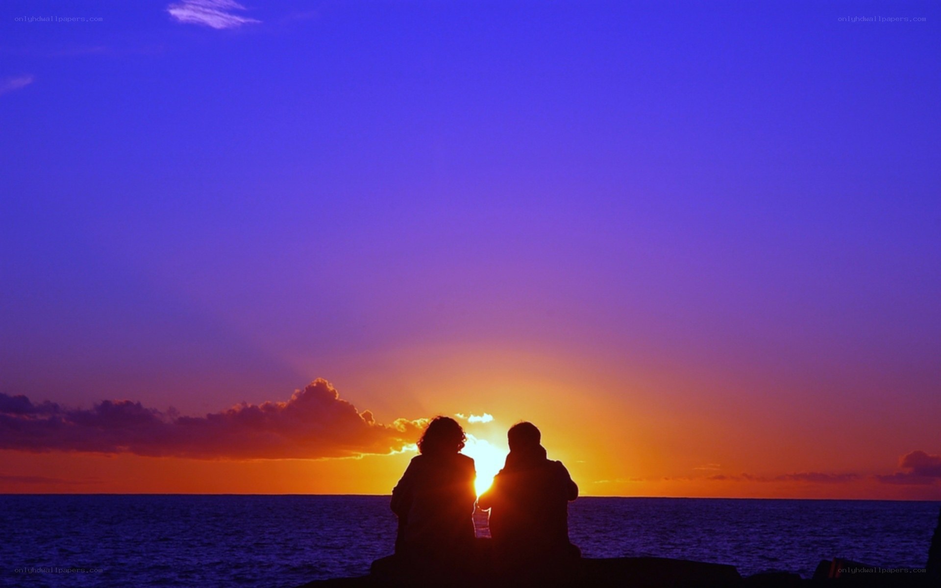Couple watching sunset at sea