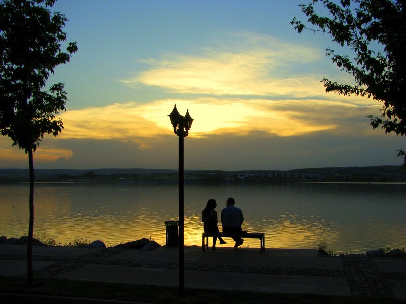 Couple watching sunset by the lake