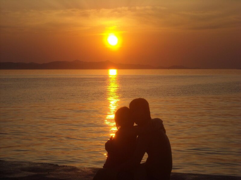 Couple watching sunset by the sea