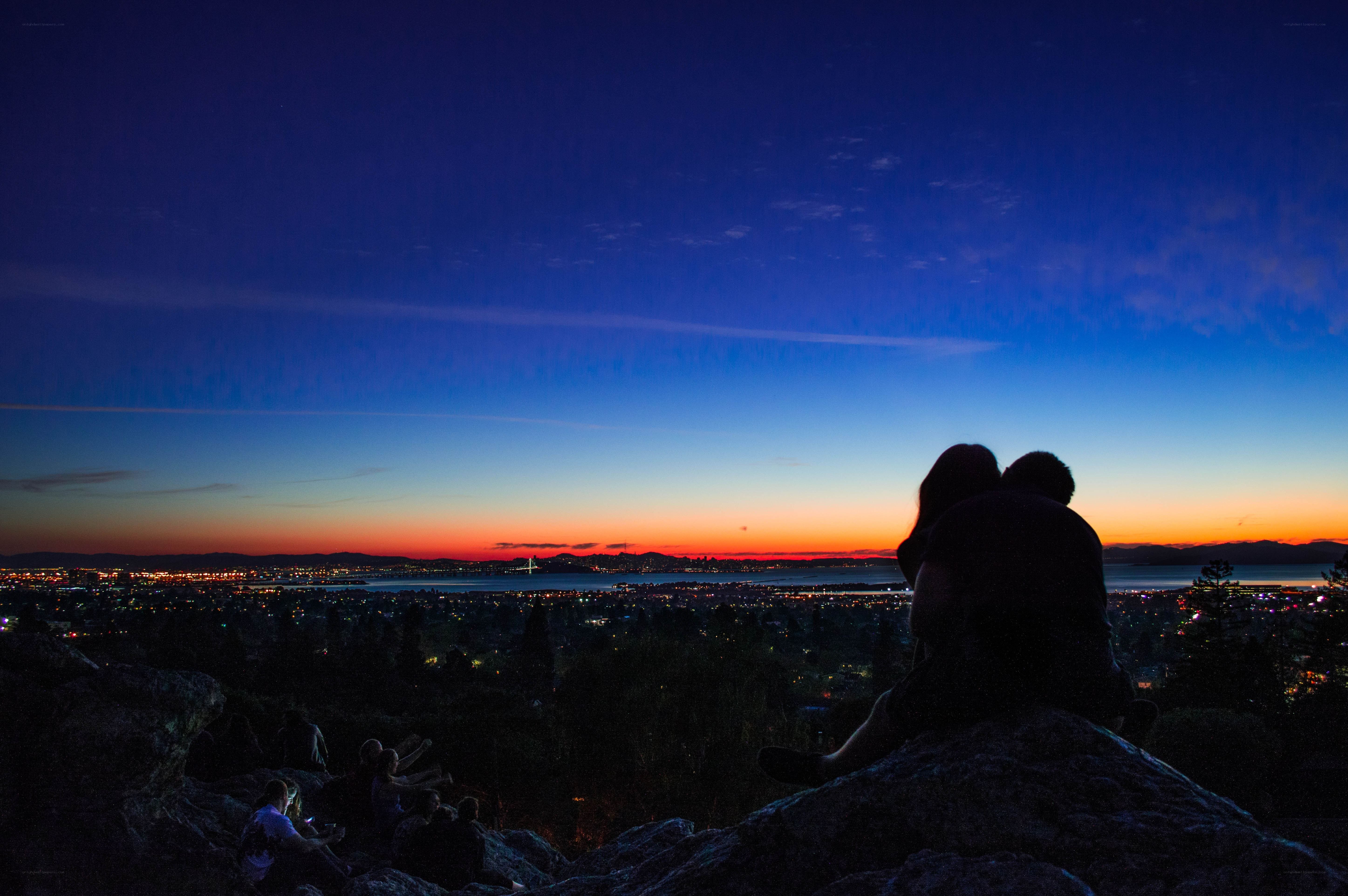 Couple watching sunset over city