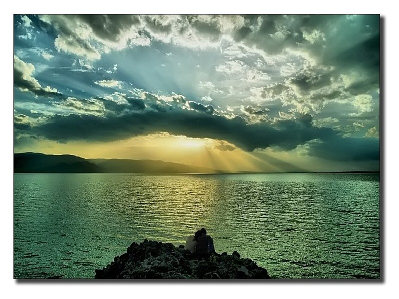 Couple watching sunset over water