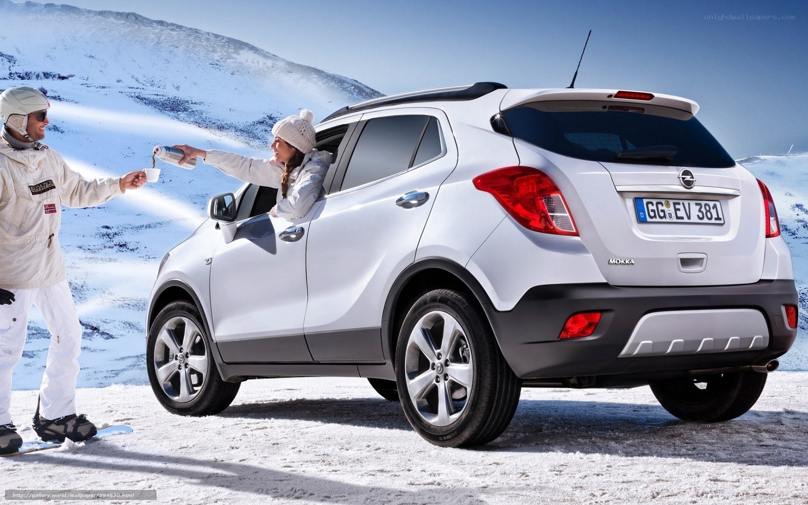 Couple with car in snowy mountains