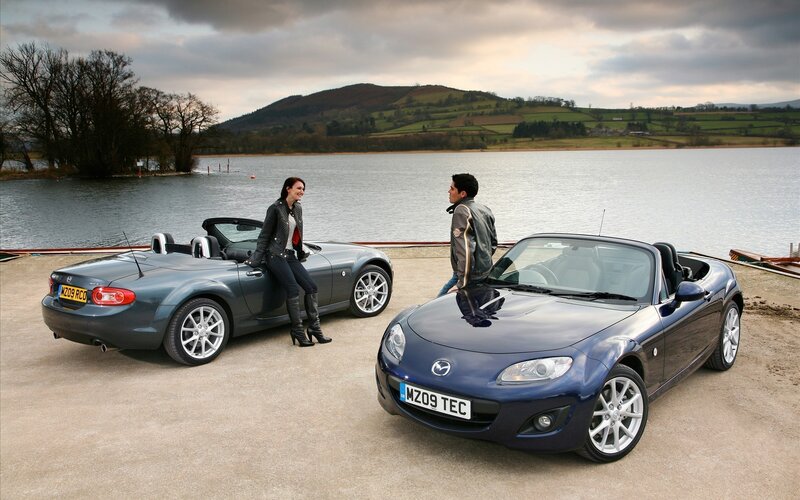 Couple with convertibles by lake