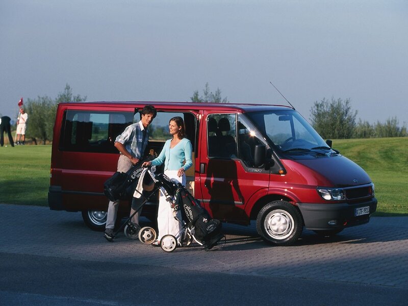 Couple with golf bags near van