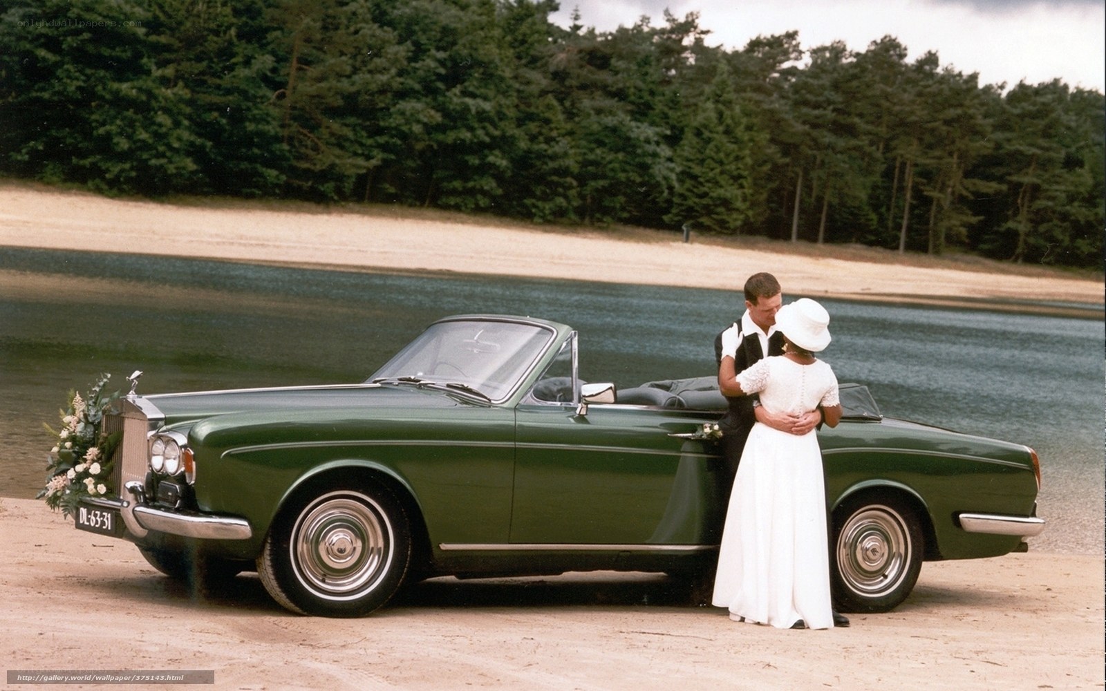 Couple with green car by lake