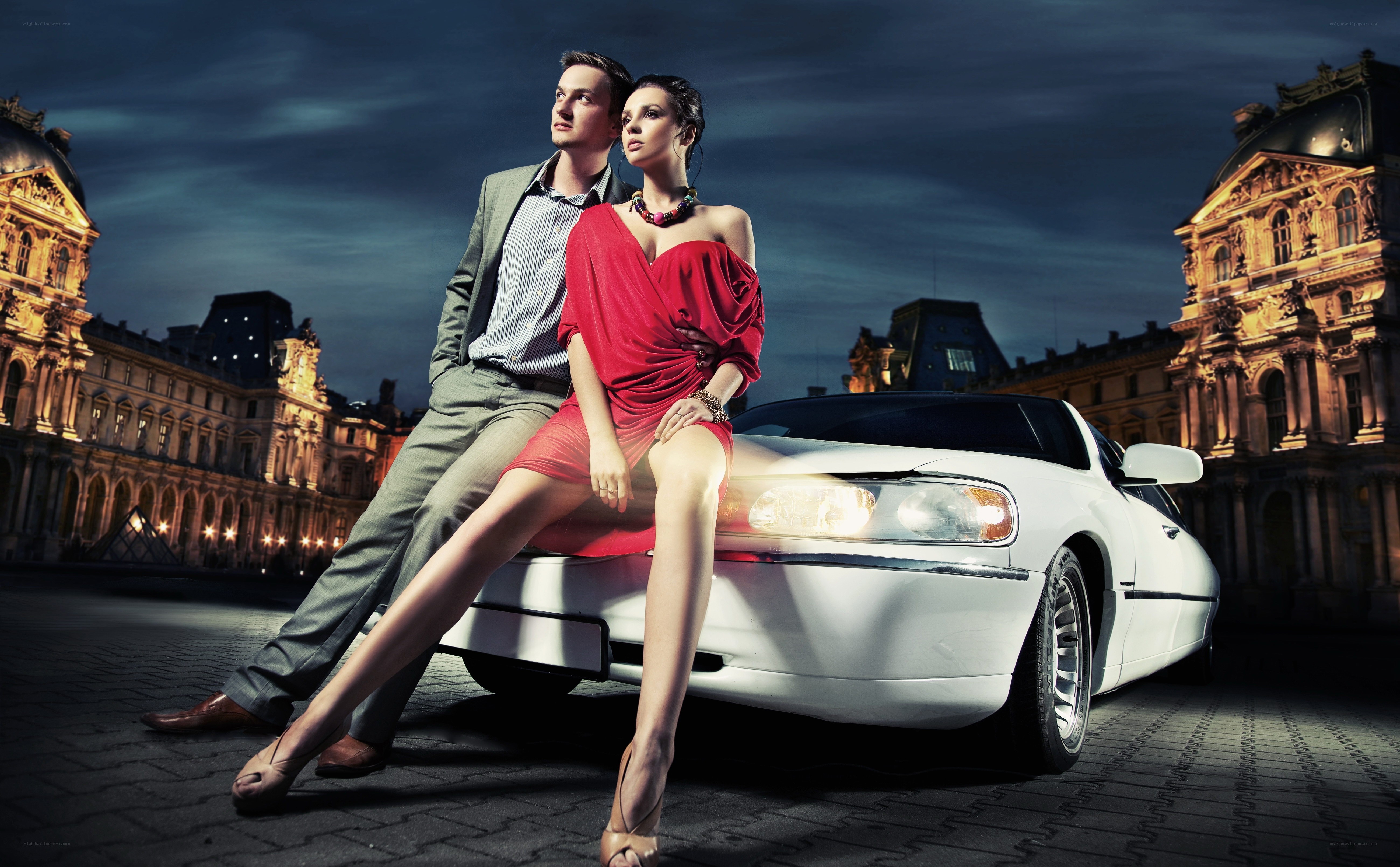 Couple with luxury car at night