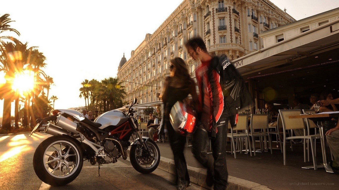 Couple with motorcycle at sunset