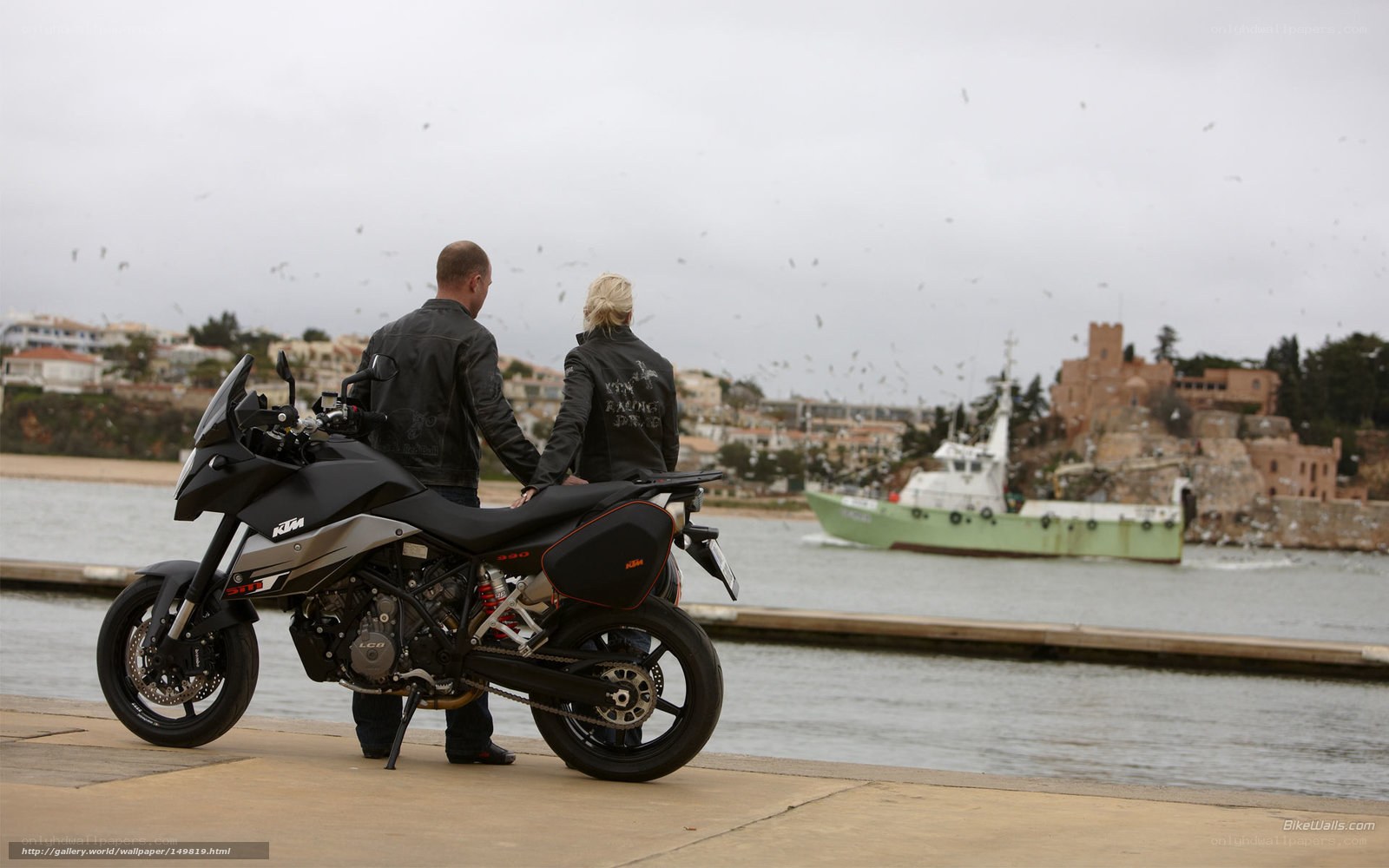 Couple with motorcycle by the harbor