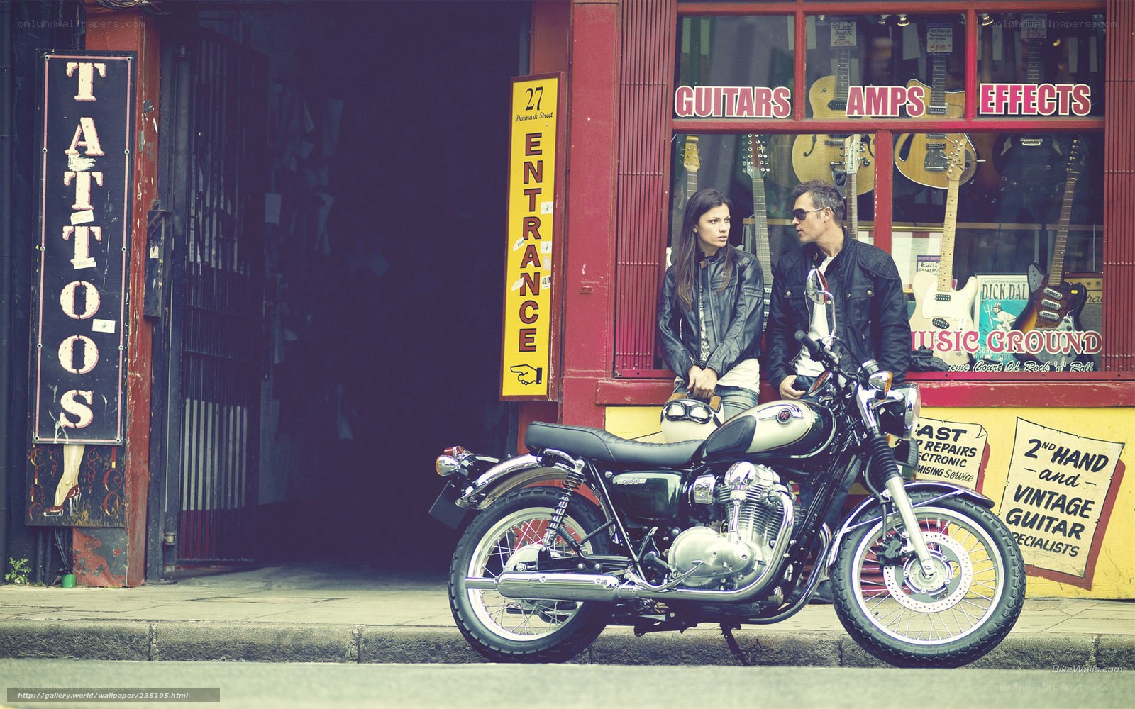 Couple with motorcycle outside music store
