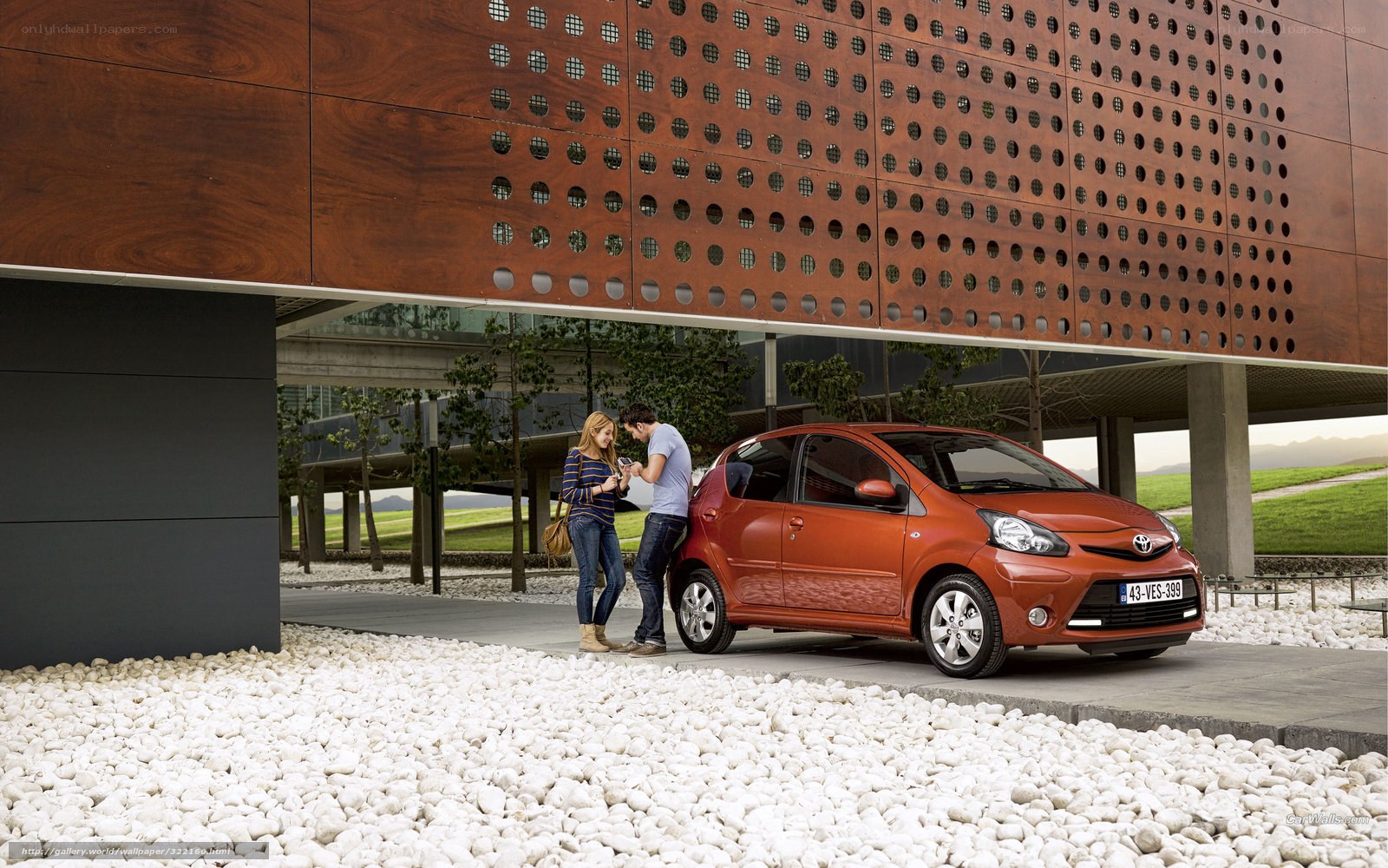 Couple with red car in modern setting
