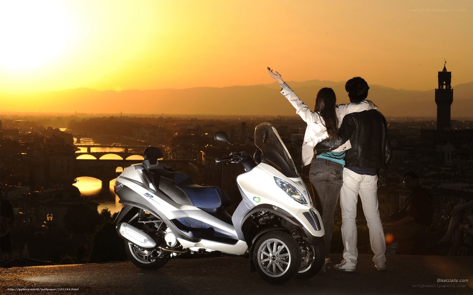 Couple with scooter at sunset