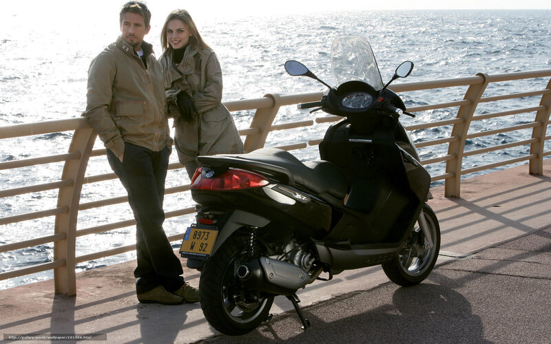Couple with scooter by the sea