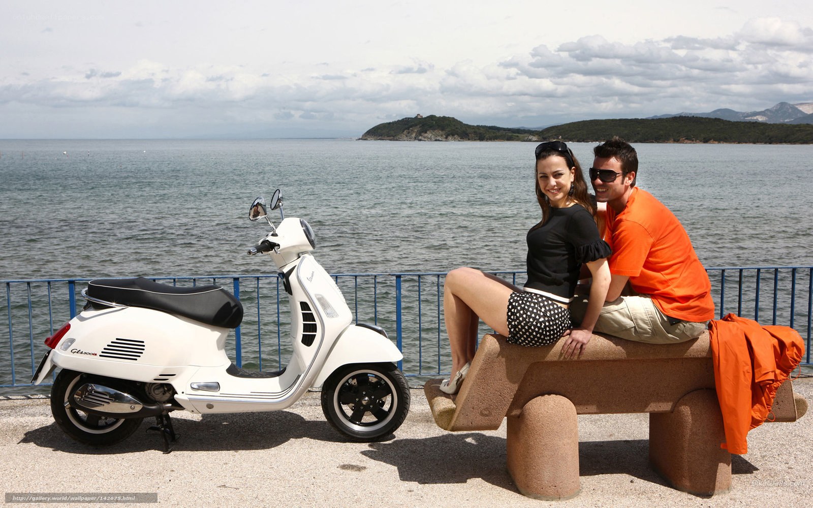 Couple with scooter by the sea