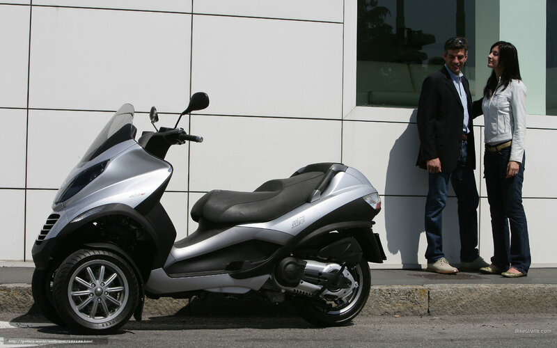Couple with scooter in front of building