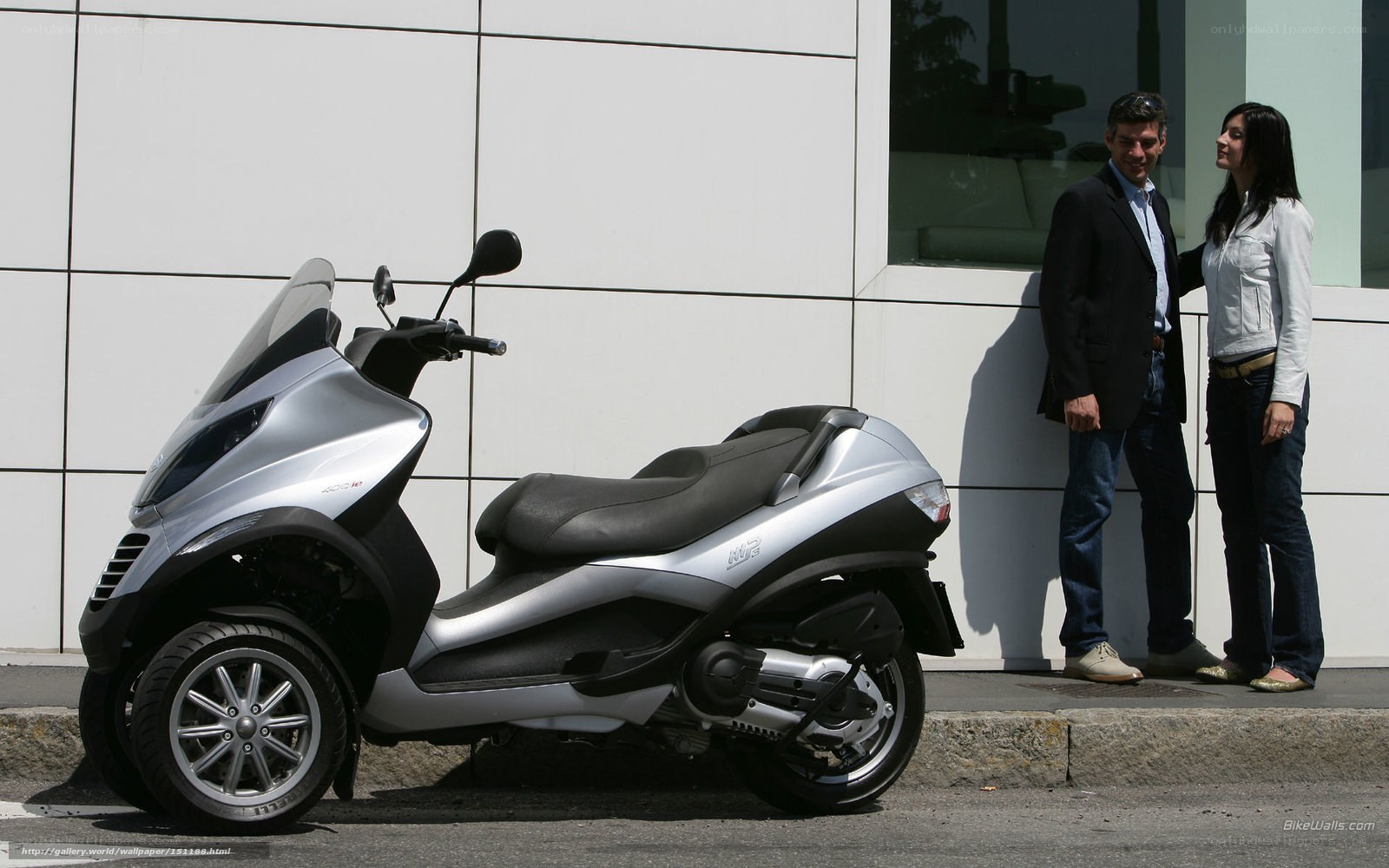 Couple with scooter in front of building