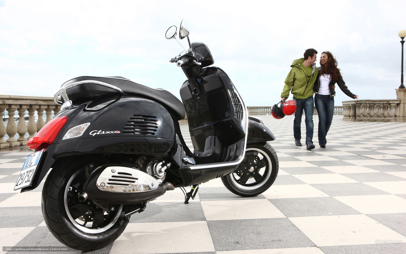 Couple with scooter on promenade
