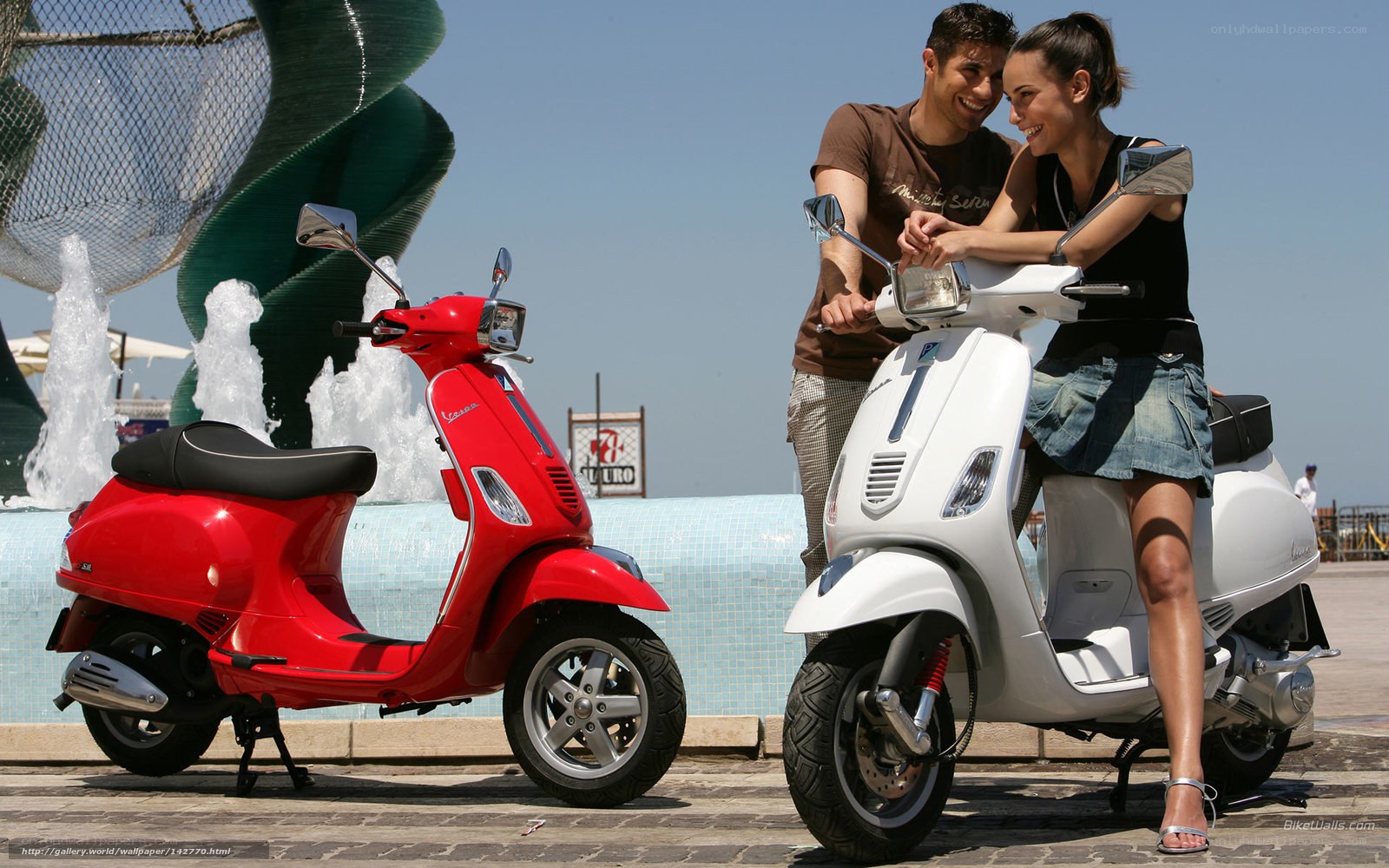 Couple with scooters by fountain