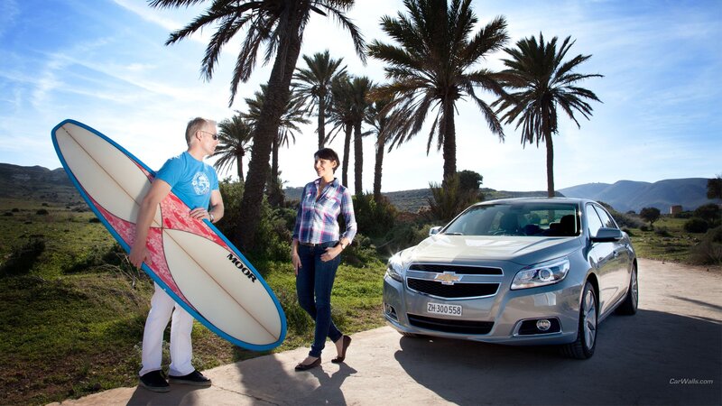 Couple with surfboard and car