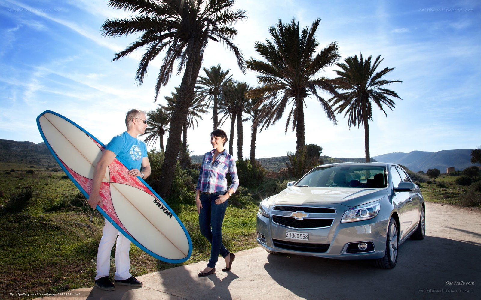Couple with surfboard and car